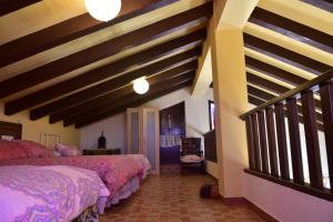 a bedroom with two beds and a ceiling with beams at Casa Rural Las Adelfas in El Gastor