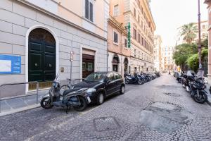 a car parked next to a row of motorcycles on a street at BDC - Opera Studio in Rome