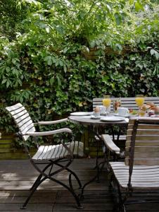 a table with two chairs and a table with drinks at Hotel Wedina an der Alster in Hamburg
