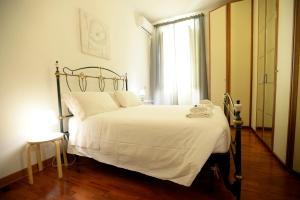 sypialnia z łóżkiem z białą pościelą i oknem w obiekcie MECENATE DELUXE COLOSSEUM w Rzymie