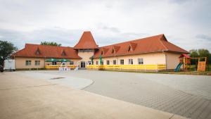 a large building with red roofs and a playground at Penzión Žemberovce in Dolné Žemberovce