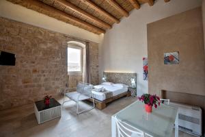 a bedroom with a bed and a table in a room at Stacci Rural Resort in Modica