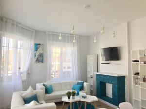 ein Wohnzimmer mit einem weißen Sofa und einem blauen Kamin in der Unterkunft Relais Vacances à la Mer in Berck-sur-Mer