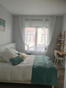 ein Schlafzimmer mit einem großen Bett und einem Fenster in der Unterkunft Relais Vacances à la Mer in Berck-sur-Mer