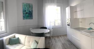 ein weißes Wohnzimmer mit einem weißen Sofa und einem Tisch in der Unterkunft Relais Vacances à la Mer in Berck-sur-Mer + 42 Fotos