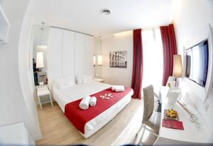 - une chambre avec un grand lit et une couverture rouge dans l'établissement Tullia&Prisca Relais, à Rome