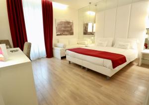- une chambre avec un grand lit blanc et une couverture rouge dans l'établissement Tullia&Prisca Relais, à Rome