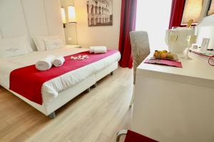 a hotel room with a bed with a red blanket at Tullia&Prisca Relais in Rome