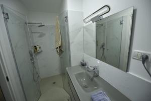 a bathroom with a sink and a shower and a mirror at Sea View Coral Suite in Eilat