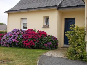 een huis met een grote heg bloemen ervoor bij Chambre d'hôtes - La Maison de Jane in Jullouville-les-Pins