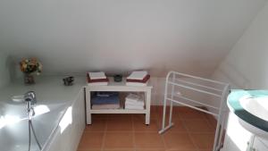 a small bathroom with a sink and a shelf at Chambre d'hôtes - La Maison de Jane in Jullouville-les-Pins