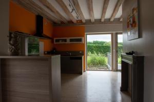 Lailly-en-ValにあるMANOIR DE BOURGNEUFのオレンジ色の壁のキッチン、オープンドア