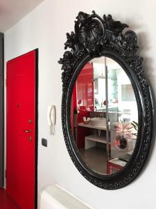 By Best Apartments في تيرانا: مرآة سوداء على جدار مع باب احمر