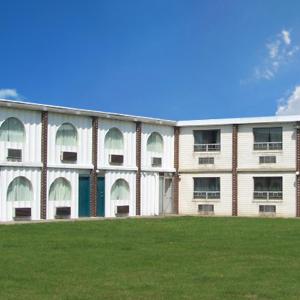 a large building with a grass field in front of it at Harbor Inn in Philipsburg