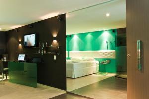 a bedroom with a white bed and a green wall at Forum Motel in Recife