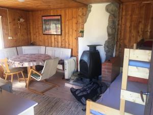 a living room with a wood stove and a table at Visit Wilderness in Åmli