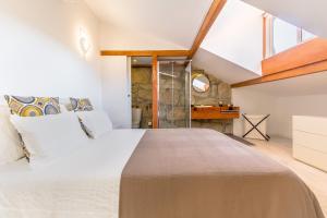 ein Schlafzimmer mit einem großen Bett und einem Fenster in der Unterkunft Gaia Woodstone Hideout in Vila Nova de Gaia