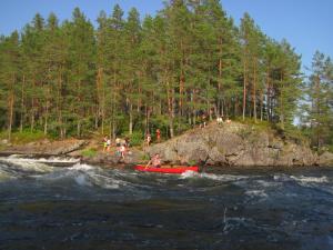 un grupo de personas en un bote rojo en el agua en Visit Wilderness en Åmli