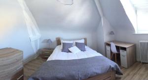 um quarto com uma cama, uma secretária e uma janela em Relais vacances à la Mer 1 em Berck