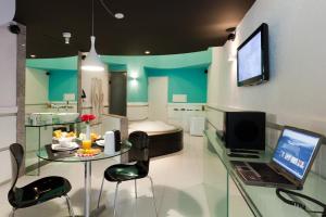 a room with a table with a laptop and a bed at Forum Motel in Recife