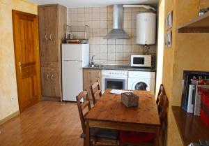 a kitchen with a table and a white refrigerator at Casa del Plantel in La Granja de San Ildefonso