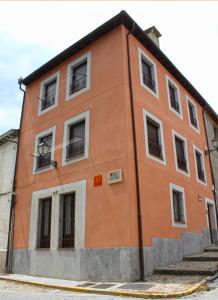 a orange building with windows on a street at Casa del Plantel in La Granja de San Ildefonso