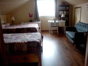 a bedroom with two beds and a couch and a window at Pension B&B Dodeman in Saint-Pierre