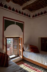 um quarto com 2 camas e uma janela em Kasbah Tigmi N'Oufella em Telouet