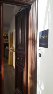 Una puerta de madera en una habitación con un cartel. en Sensation House en Roma