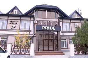 un edificio con un cartel de precio delante en Pride Hotel, en Taraz
