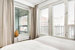 - une chambre avec un lit et 2 grandes fenêtres dans l'établissement Haave Apartments Tampere, à Tampere