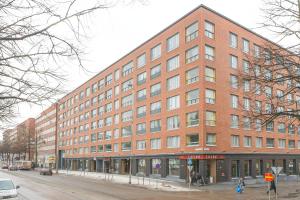 un grande edificio in mattoni rossi su una strada cittadina di Haave Apartments Tampere a Tampere