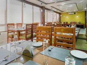una sala da pranzo con tavoli, sedie, tavolo e sedie. di Pemaling Lords Eco Inn Guwahati a Guwahati