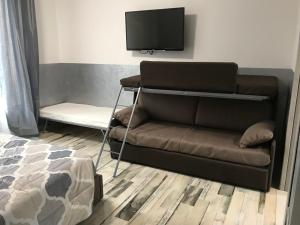 sala de estar con sofá y TV de pantalla plana en B&B ATTICO GALLIERA en Bolonia
