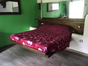 sypialnia z łóżkiem z czerwoną kołdrą i lustrem w obiekcie Leamorine House w mieście Predappio