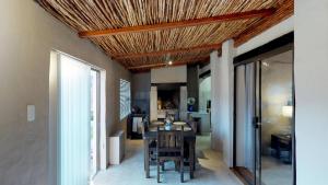 a kitchen with a dining room table with a ceiling at Swartberg Pass Cottages in Matjiesrivier