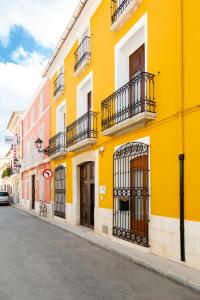 un edificio amarillo con balcones en una calle en Noguera Casa Rural Casa de Poble, en Jalón