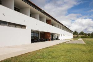 an external view of a white building with grass at Hotel Rural Santo Antonio in Arronches