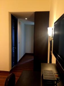 a room with a television and a room with a hallway at La Residence in Gurgaon