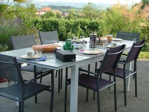 a table with chairs and food on it at Les Enselmes in Montagnieu