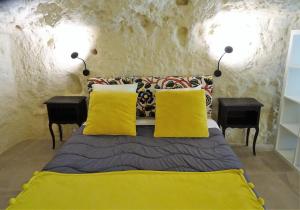 een slaapkamer met een bed met gele kussens en 2 tafels bij Gite de Loup-Terre in Tours