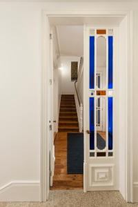 a hallway with a staircase with blue walls and a door at naBaixa Apartments in Porto