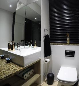 y baño con lavabo blanco y espejo. en 205 New Cumberland, en Ciudad del Cabo