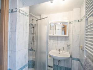 een witte badkamer met een wastafel en een douche bij Ferienwohnung in der Telle in Schmalkalden