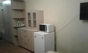 a small kitchen with a microwave on top of a refrigerator at Apartments Zhambyl 159 in Almaty +6 photos