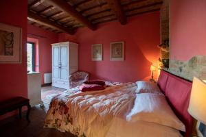 サン・ジミニャーノにあるPodere San Luigiの赤い壁のベッド1台が備わるベッドルーム1室