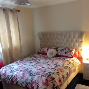 a bedroom with a bed with a floral comforter at The Lodge Guest House in Grain