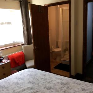 a bedroom with a bed and a bathroom with a toilet at The Lodge Guest House in Grain