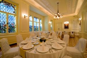 a banquet hall with white tables and chairs and windows at Boutique Hotel Victoria Budapest in Budapest