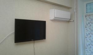 a flat screen tv hanging on a wall at Apartments Zhambyl 159 in Almaty